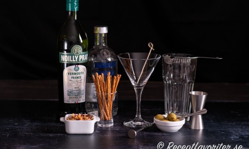 Till drinken behöver du torr vermouth och vodka. Vidare martiniglas, rörglas, sil, cl-mått och oliver. 