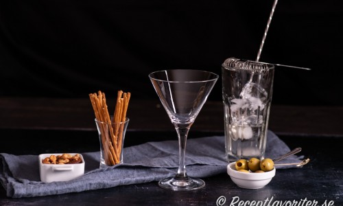 Mät upp vodka och martini i ett rörglas med is och sila sedan över i martiniglaset. 