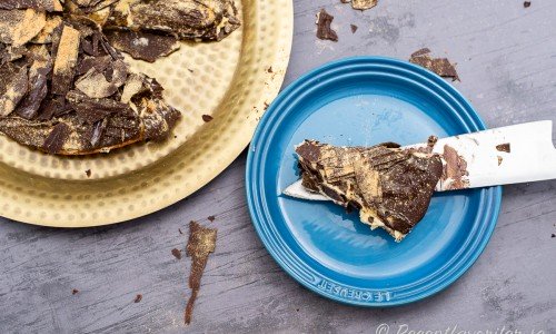 Skär upp tårtan försiktigt med spetsen på en kniv så att chokladlagret överst spricker så lite som möjligt.  