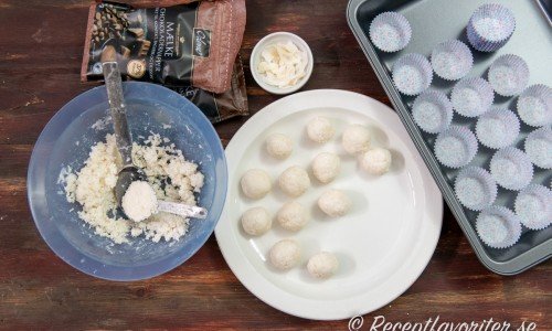 Smält ihop kokosolja, kokosgrädde och kokosflingor till en röra. Forma 20 små bollar. 