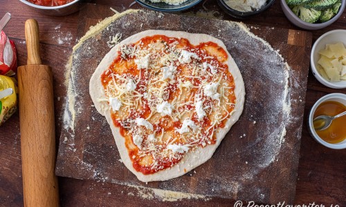 Toppa degen med tomatsås, riven mozzarella samt färsk mozzarella. 