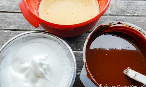 Förbered delarna till chokladmoussen: vispad äggvita, vispad äggula samt smält choklad blandad med smör och honung. 