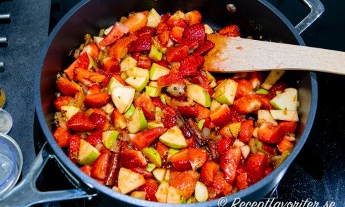 Jordgubbar, äpple, chili med flera ingredienser kokas i panna till chutney