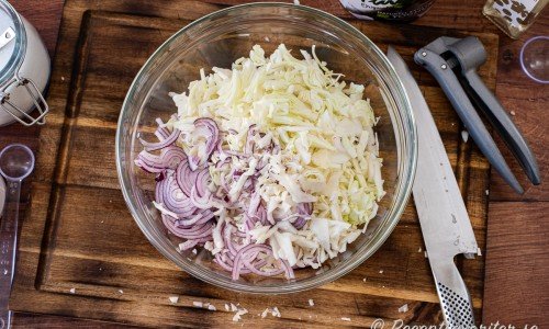 Strimla vitkål och rödlök samt lägg med salt, vinäger och socker i en bunke. 