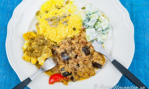 En mustig vegetarisk currygryta med sojafärs på tallrik serverad med tillbehör