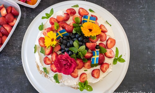 En gräddtårta som är enkel att göra med färdiga tårtbottnar fyllda med sylt och vaniljkräm toppad med grädde och bär, citronmeliss samt blommor. 