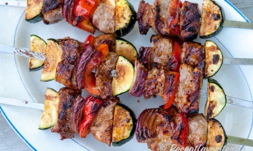 Varva fläskfilébitarna med rödlök, zucchini och paprika - fina färger och det håller köttet saftigt när du grillar det. 