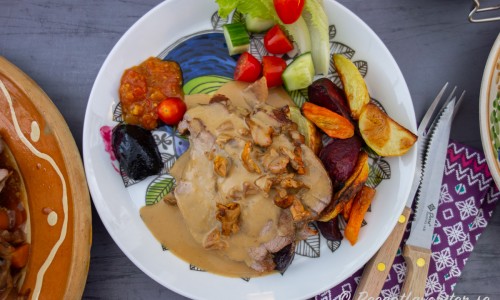 Fläskkarrén serverad med tillbehören på tallrik. 