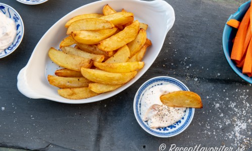 Friterad klyftpotatis på fat med dippsås och morotsstavar