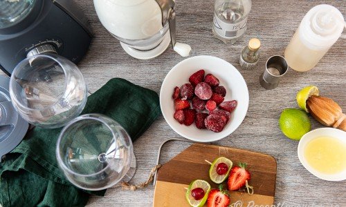 Ingredienser till den alkoholfria jordgubbsdaiquirin: krossad is, vichyvatten, sockerlag, ljus romessens, frysta jordgubbar, färskpressad lime och garnering med lime, cocktailbär och jordgubbe på bampuspett.  