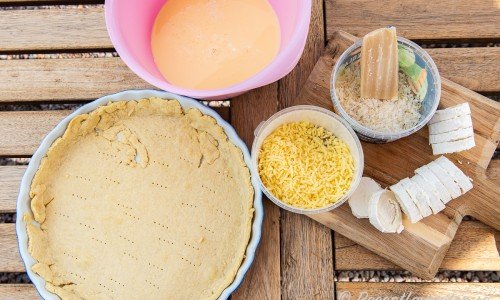 Ingredienser till Quiche Lorraine - äggstanning, förgräddat pajskal, getost i rulle, riven chevrette och lagrad ost. 