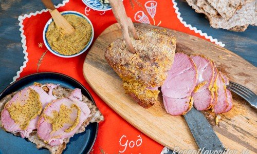 Julskinkan serverad på skärbräda med senap, smör och knäckebröd