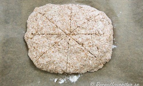 Knåda ihop degen och forma till ett rektangulärt bröd på en bakplåt med bakplåtspapper. Markera ut med kniv några skåror i brödet ex. som tårtbitar. 