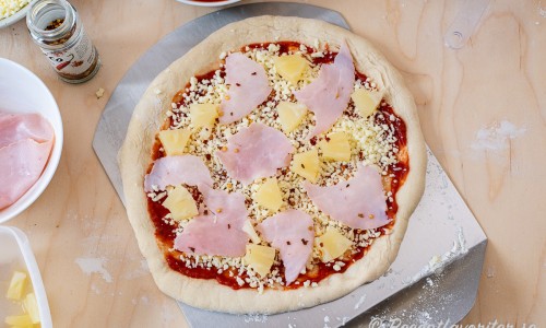 Bred ut pizzasås, ost, skinka och bitar av ananas. Strö vidare över lite chiliflakes om du önskar det. 