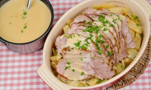 Helstekt karré eller kotlett med sås från stekskyn samt rotgrönsaker som vitkål som fått steka med köttet. 