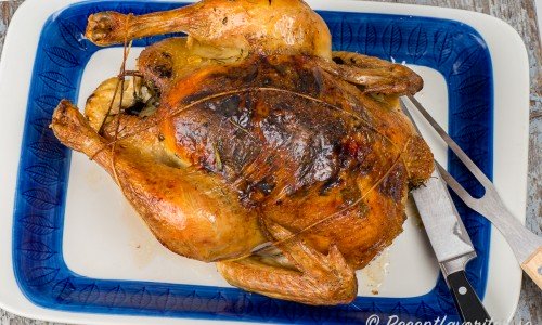 Kycklingen serverad på fat redo att skäras upp till servering. 