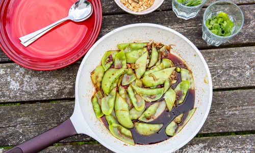 Ärtorna smaksätts i stekpanna eller wok med sojamarinaden och toppas med jordnötter och färsk koriander. 
