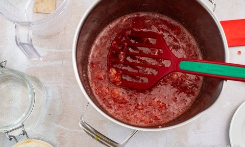 Mosa ihop jordgubbar och socker med en potatisstöt. 