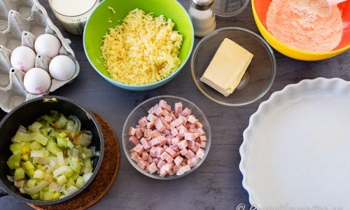 Ingredienser till pajen: stekt purjolök, ägg, grädde, riven ost, tärnad kassler, smör, vatten och vetemjöl. 