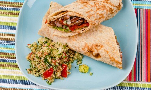 Kebabrulle på tallrik serverad med Tabbouleh - bulgursallad. 