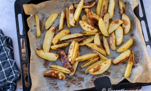 Tillaga potatisklyftorna med lite olja och salt i en långpanna 25 minuter i ugnen på 225 grader. 