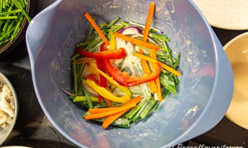 Grönsakerna blandas med pannkakssmeten i en skål. 
