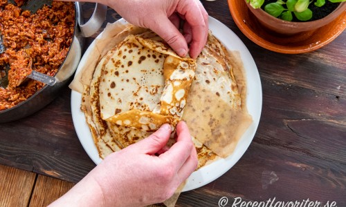 Vik över kanten på pannkakan samt vi in kanterna och rulla ihop till rulader. 