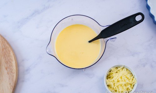 Blanda ihop ägg, grädda, mjölk och salt till en äggstanning. Vänd i hälften av osten. 