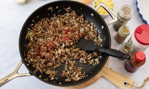 Tillsätt tomatpure, sambal oelek, oregano, rosmarin, svartpeppar samt salt och stek på låg värme medan du förbereder pajskalet. 