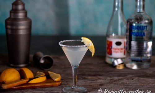 Till Lemon Drop cocktail behöver du en shaker med sil och is, kylt martiniglas, citron, socker, apelsinlikör och vodka. 