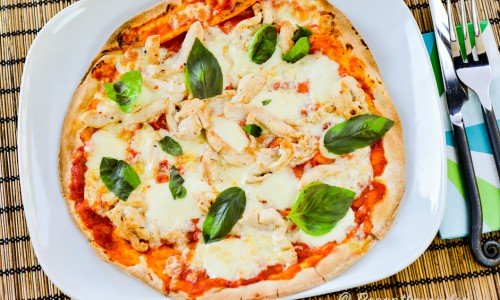 Libapizza med kyckling, mozzarella och basilika på tallrik