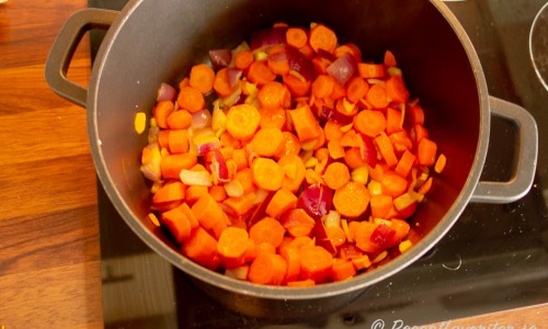 Slantade morötter med lök och vitlök som fräses till soppan