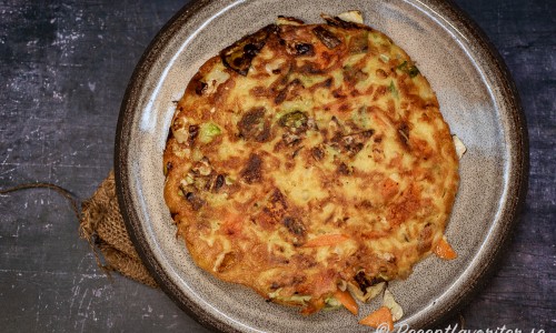 Okonomiyaki läggs upp på skärbräda, fat eller tallrik och toppas sedan med japansk majonnäs, Okonomiyaki-sås, katsuobushi torkad fisk samt strimlad salladslök.  t 