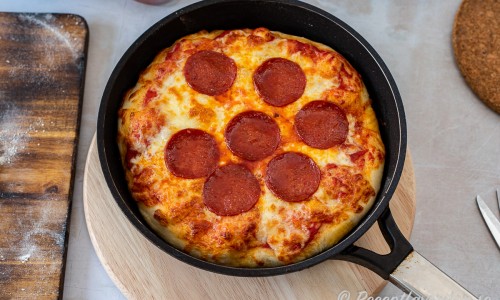Panpizza i amerikansk stil med tjock knaprig botten, pizzasås, riven mozzarella och pepperoni salami. 
