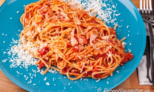 Pasta med bacon, tomat och parmesan på tallrik