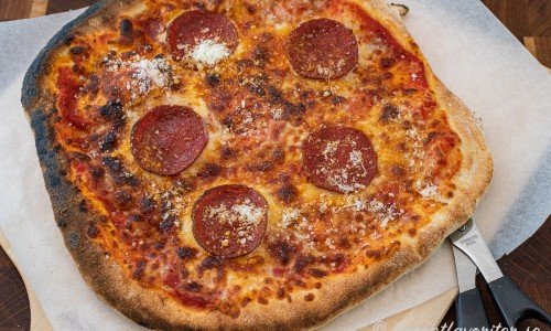Pizza med pepperoni salami samt tomat, mozzarella och parmesan. 
