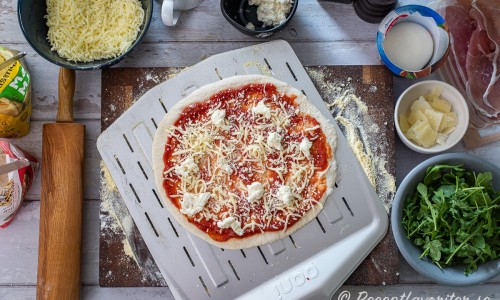 Med mycket mjöl under pizzan är det lätt att i hastiga ryck få upp pizzan på en pizzaspade. 