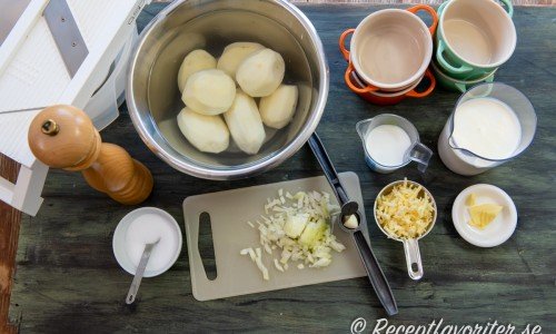 Till gratängerna behöver du skalad potatis, vitpeppar, salt, gul lök, vitlök, grädde, mjölk och riven ost. 