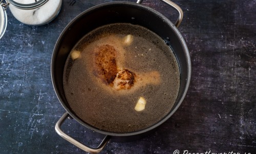 Kyckling, ingefära och vitlök täcks med vatten och får koka 1,5 timmar under lock på låg värme. 