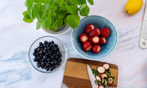 Förbered önskad garnering. Förslagsvis skivade jordgubbar, blåbär och citronmeliss. 