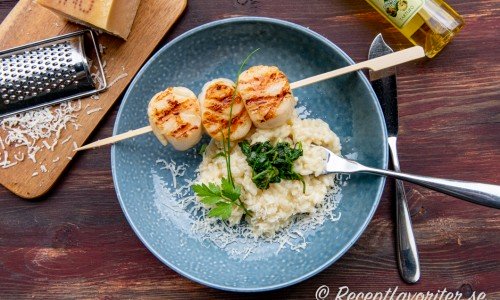 Risotto serverad med parmesan och lite spenat samt pilgrimsmusslor. 