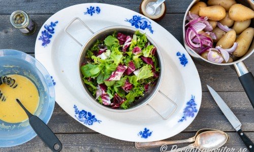 Salladsdressing, grönsallad samt kokt potatis med skivad rödlök. 