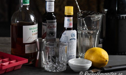 Ingredienser till Sazerac cocktail: is, trestjärnig konjak, absinthe, Bitters, socker och citron. 