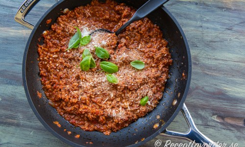 Lök, vitlök och sojafärs fräses och kokas ihop med tomatpuré, krossade tomater och kryddor. 