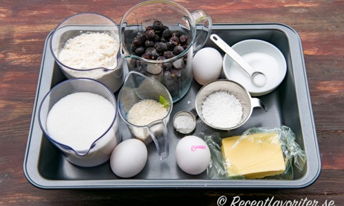 Ingredienser till svartvinbärskakan: Socker, vetemjöl, ägg, kokosflingor, frysta svarta vinbär, vaniljsocker, pärlsocker, salt och smör. 