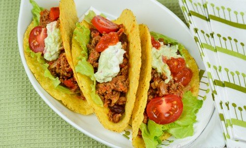 Tacosskal med köttfärs, guacamole, tomat, isbergssallad och bönor.