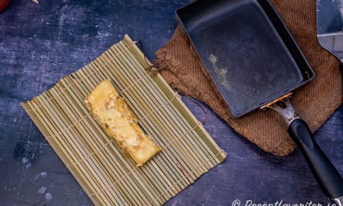 Omelettrullen läggs på en bambumatta eller sushimatta. 