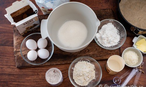 Ingredienser till tårtbottnen: kakao, ägg, vaniljsocker, vetemjöl, strösocker, potatismjöl, bakpulver och smör. 