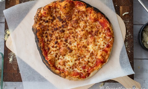 Efter grunden till pizzan är gräddad kan den toppas med grönt och pesto. 