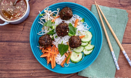 Risnudlarna blandas med grönsaker till en nudelsallad och toppas med vegobullar samt några skedar dressing. Även hackade jordnötter är gott på. 